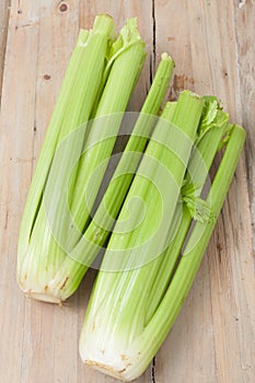 Organic celery stalks on wooden background