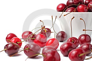 Organic cherry berries in a ceramic bowl, white background, close-up