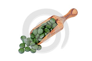 Organic chlorella and spirulina pills in a wooden scoop isolated on white