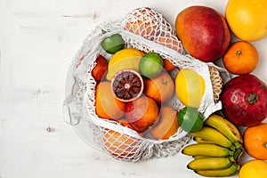 Organic citrus fruits variety in cotton mesh reusable shopping bag - recycling, sustainable lifestyle, zero waste, no plastic