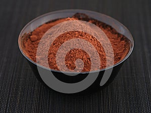 Organic cocoa powder in a black bowl