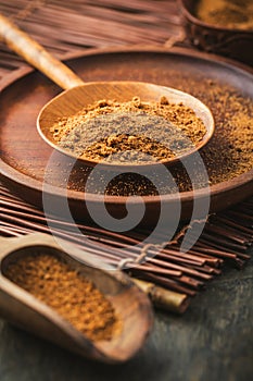 Organic coconut palm sugar in wooden scoop and bowl