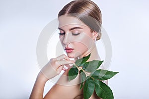Organic cosmetic . Beautiful woman face portrait with green leaf , concept for skin care or organic cosmetics