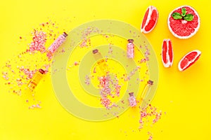 Organic cosmetic with grapefruit for homemade spa with salt and fresh fruit on yellow background top view mock-up