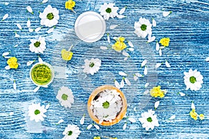 Organic cosmetics with camomile on blue background top view