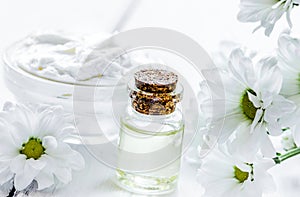 organic cosmetics with camomile extract on wooden table backgrou