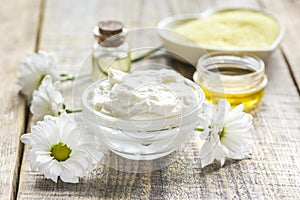 Organic cosmetics with camomile extract on wooden table background