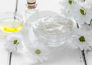 Organic cosmetics with camomile extract on wooden table background