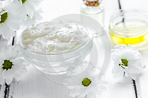 organic cosmetics with camomile extract on wooden table background