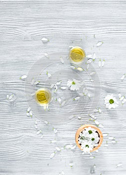 Organic cosmetics with camomile on wooden background top view