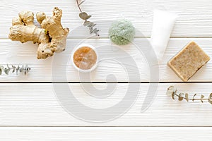 Organic cosmetics with ginger and herbs on white wooden background top view mockup