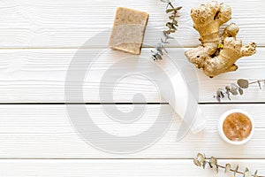 Organic cosmetics with ginger and herbs on white wooden background top view mockup