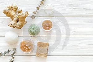 Organic cosmetics with ginger and herbs on white wooden background top view mockup