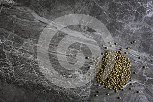 Organic dried coriander seeds on a mable kitchen worktop background