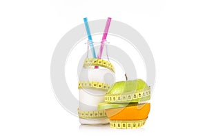 Organic drink and half of green apple and orange wrapped with a yellow tape measure.Health food and diet concept.