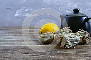 Organic dry lemongrass Cymbopogon flexuosus in bunches and lemon fruit on a wooden table.