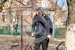 Organic ecological agriculture. Defocus farmer man spraying tree with manual pesticide sprayer against insects in spring