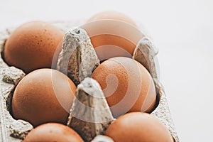organic eggs in egg box on white marble kitchen table