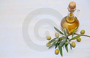 Organic Extra virgin olive oil in a bottle with green olives branch with olives on a blue background Healthy food Mediterranean