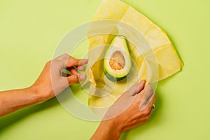 Organic fabric covers for food storage. Unrecognizable woman`s hands holds reusable Beeswax Food Wraps with half of photo