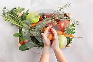 Organic farm vegetables in wooden box, vegetarian food concept child hands