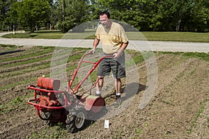 Organic Farmer Cultivating Between Rows In A Hot Sun photo