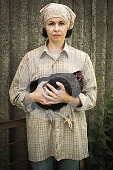 Organic farmer holding chicken under his arms