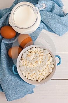 Organic farming cottage cheese in a blue bowl, eggs and milk