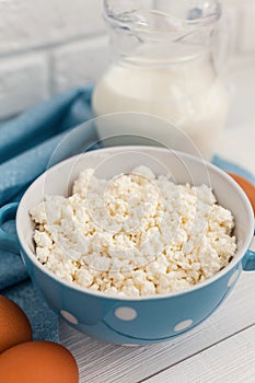 Organic farming cottage cheese in a blue bowl, eggs and milk