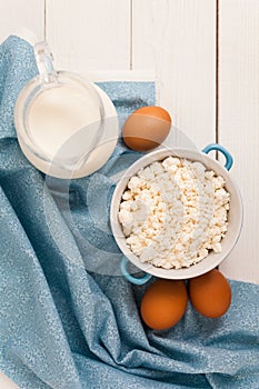 Organic farming cottage cheese in a blue bowl, eggs and milk