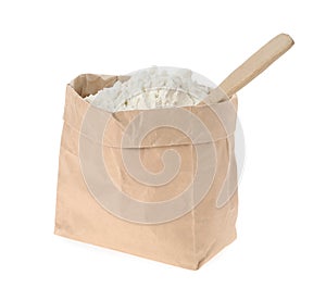 Organic flour and spoon in paper bag on white