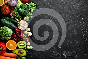 Organic food on a black stone background. Vegetables and fruits.