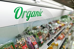 Organic food signage on modern supermarket fresh produce vegetable aisle