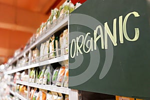Organic food signage on modern supermarket grocery aisle