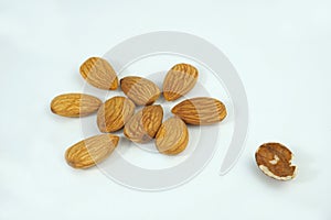 Organic fresh almonds and a bad almond out of the group  on white background