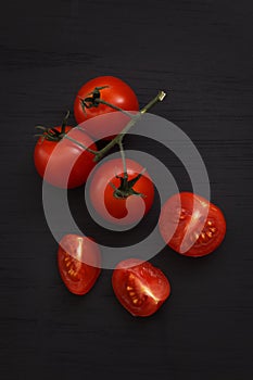 Organic fresh cherry tomatoes on black board background