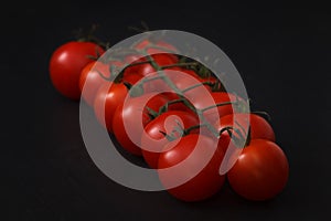 Organic fresh cherry tomatoes on black board background