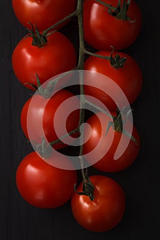 Organic fresh cherry tomatoes on black board background