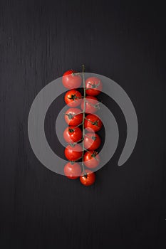 Organic fresh cherry tomatoes on black board background