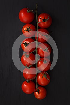 Organic fresh cherry tomatoes on black board background