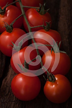 Organic fresh cherry tomatoes on wooden background