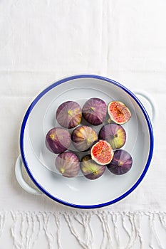Organic fresh figs in bowl on white kitche table photo