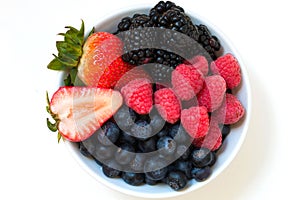 Organic fresh mixed berries fruit in a bowl on the table.