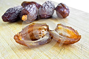 Organic fresh nutritious dried hurma dates medjool grains, on cutting board