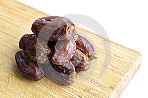 Organic fresh nutritious dried hurma dates medjool grains, on cutting board