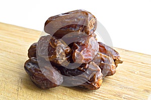 Organic fresh nutritious dried hurma dates medjool grains, on cutting board