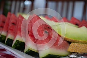 Organic fresh sliced watermelon and melon on a white tray