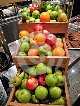Organic fruits displayed in wooden crates for a breakfast buffet