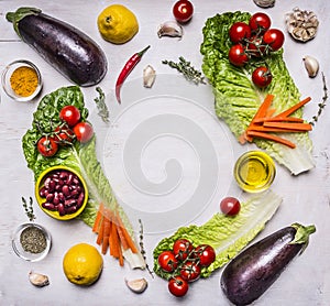 Organic garden vegetables ingredients, place for text,frame on wooden rustic background top view vegetarian concept