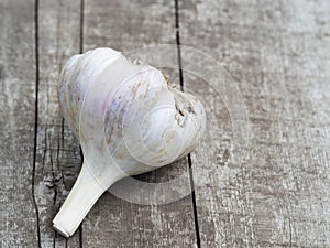 Organic garlic bulbs on a wooden table in the background